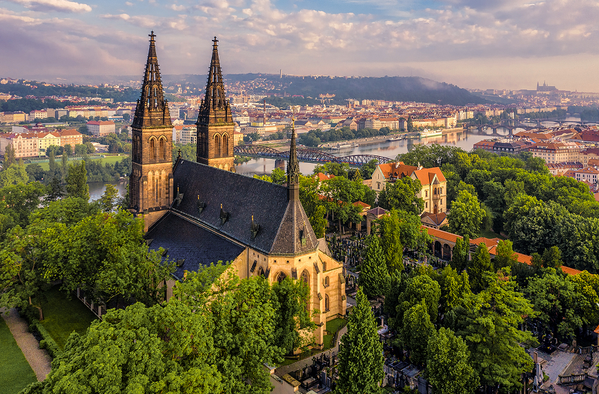 Vyšehrad fortress at golden hour with Gothic churches, city views, and Vltava River glowing in warm morning light